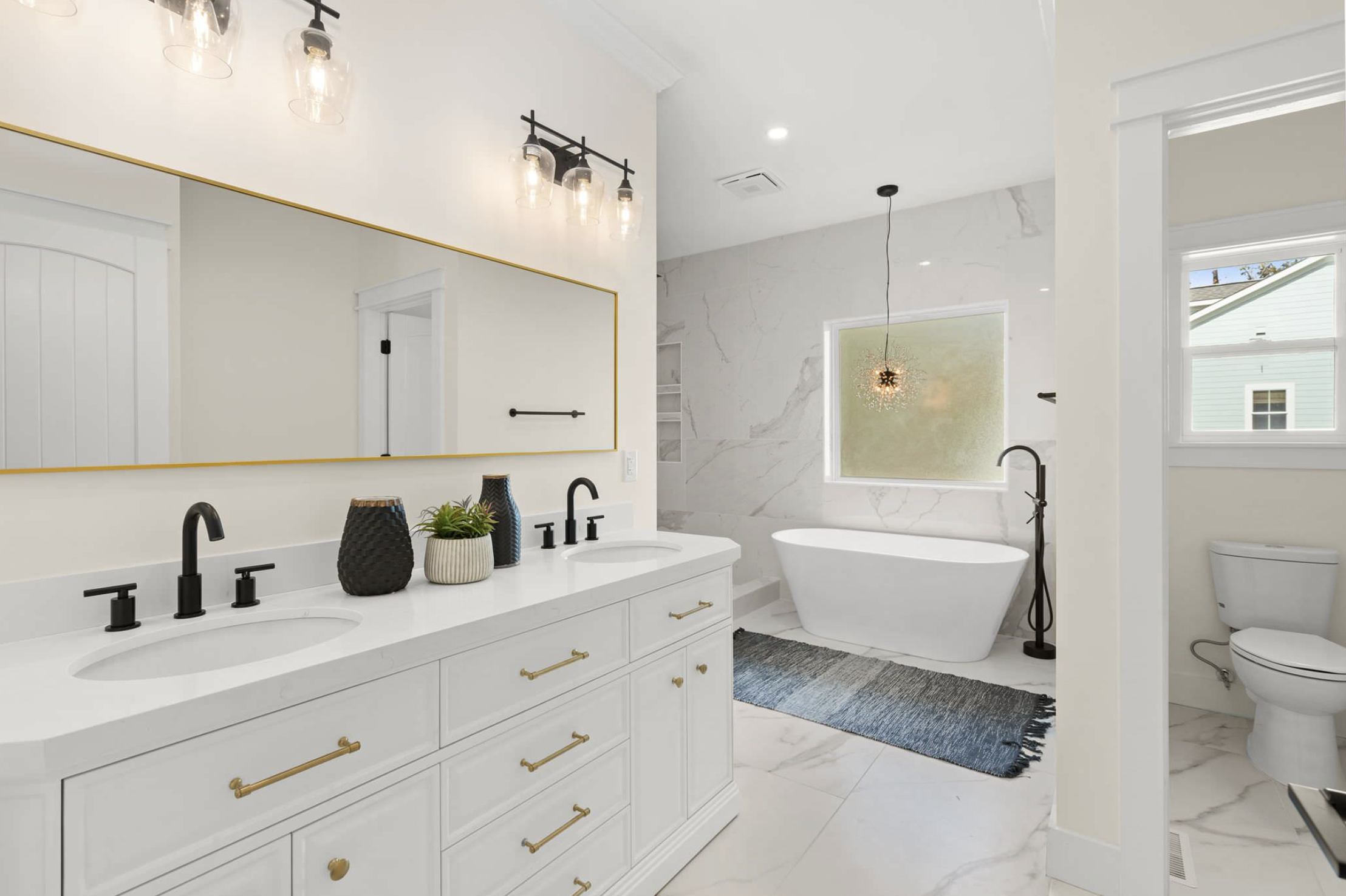 Primary bath with freestanding tub and gold-framed mirror