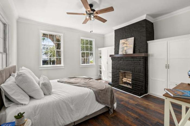 Primary bedroom with black brick fireplace and built-ins