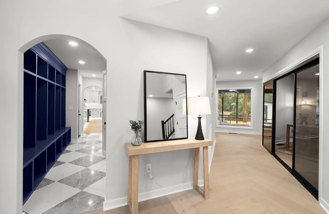 Hallway with navy mudroom archway and console table