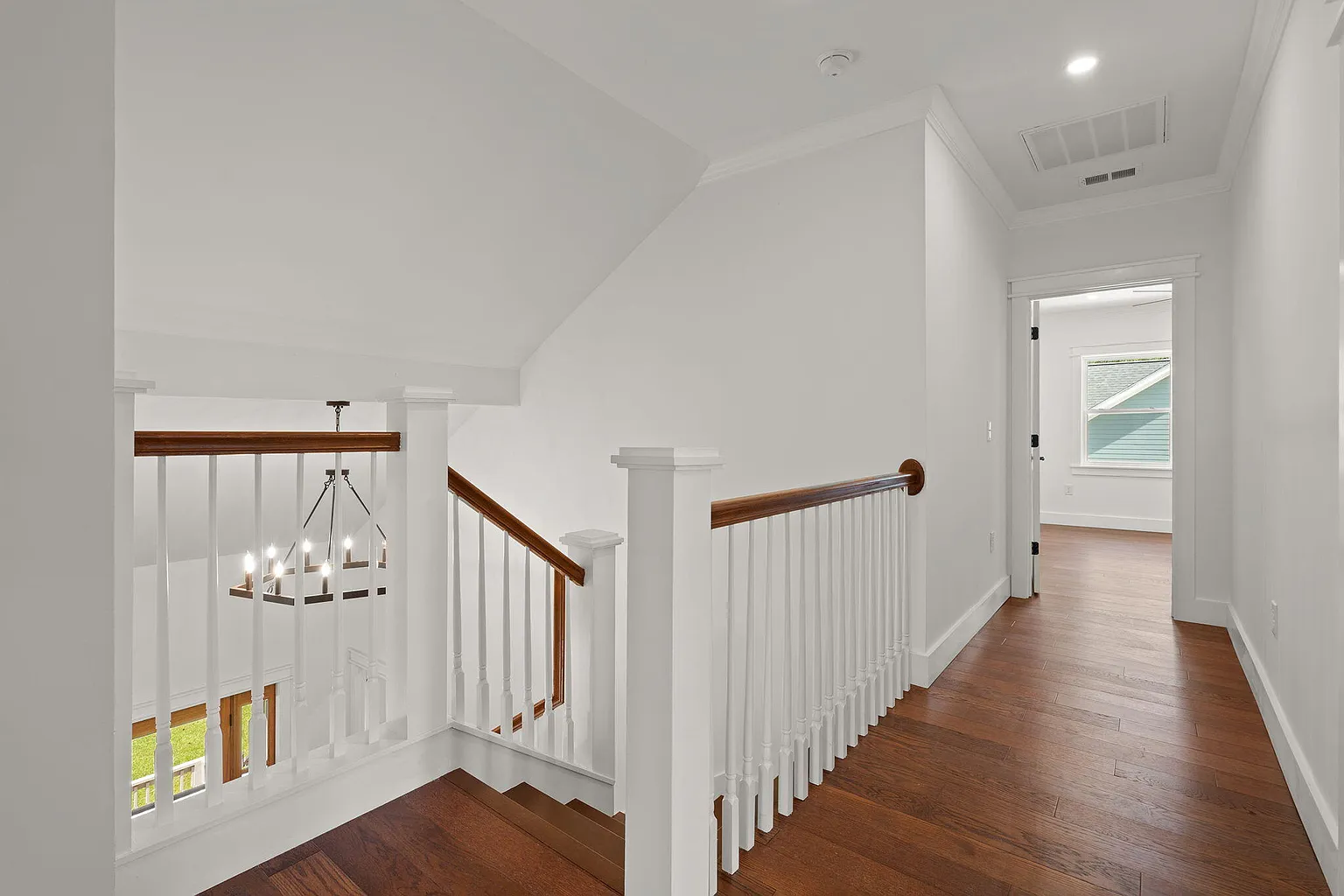 Upstairs hallway landing with staircase and box chandelier
