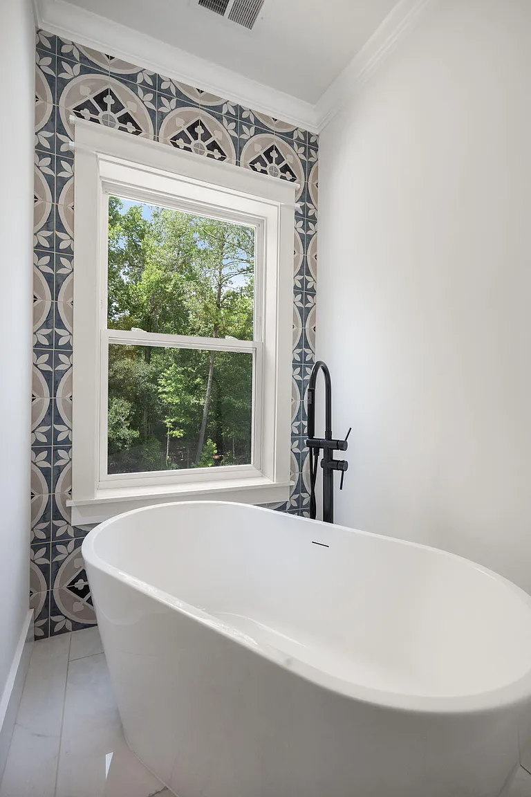 Freestanding tub with black tub filler and quatrefoil tile