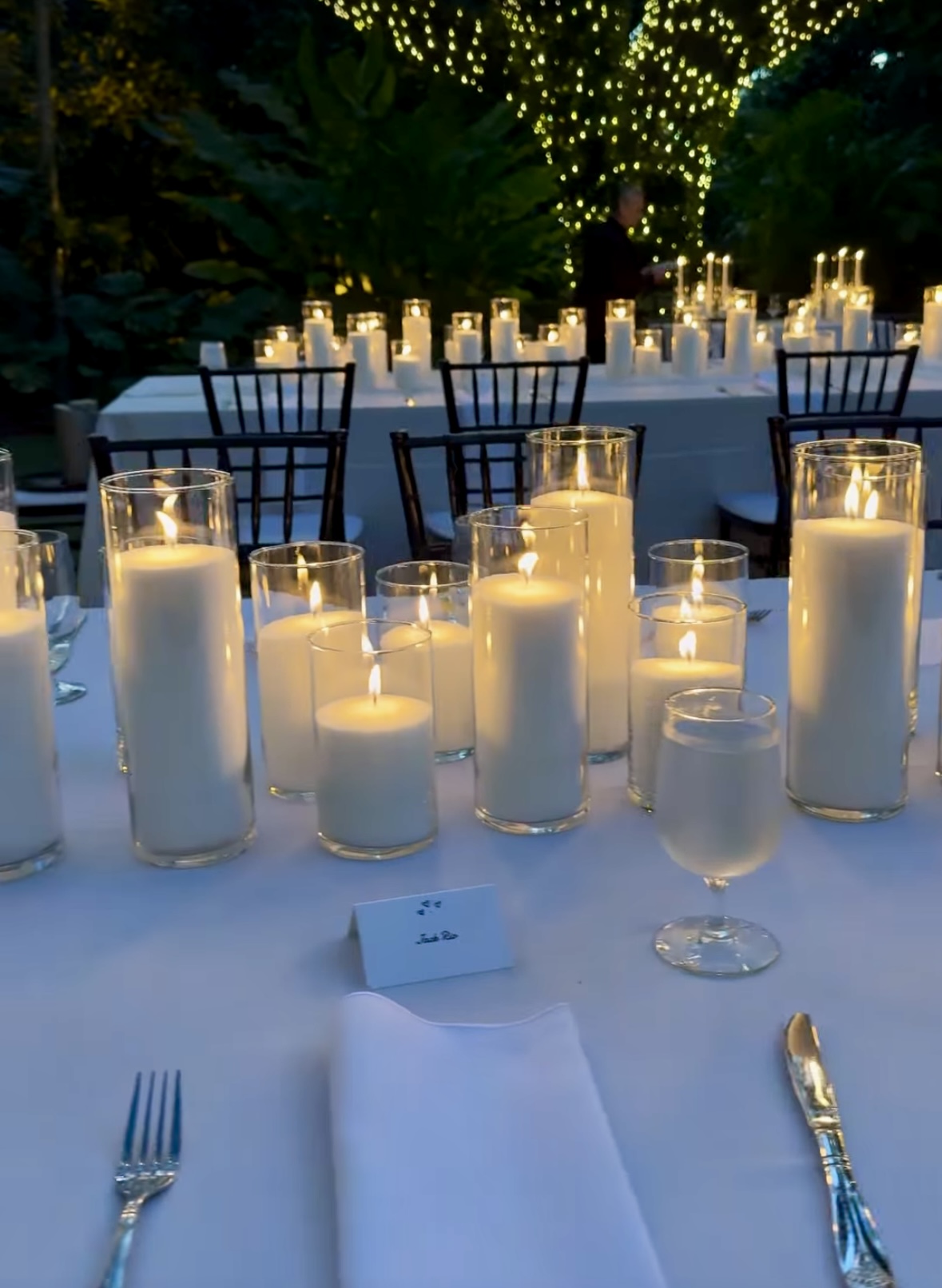 Marque-place et couverts dressés à la lueur des bougies pour un dîner de mariage