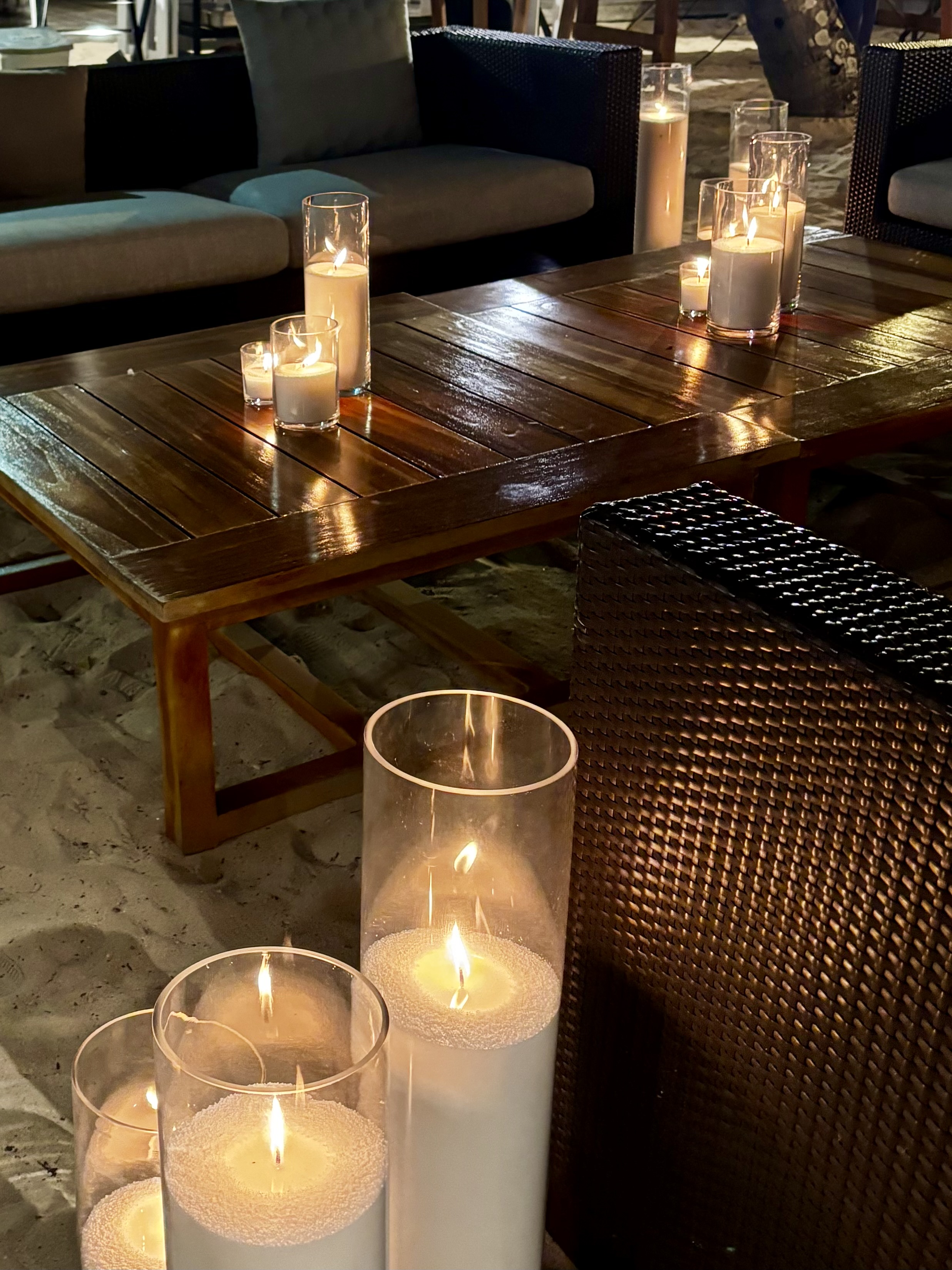 Table de réception éclairée aux bougies sur la plage en soirée