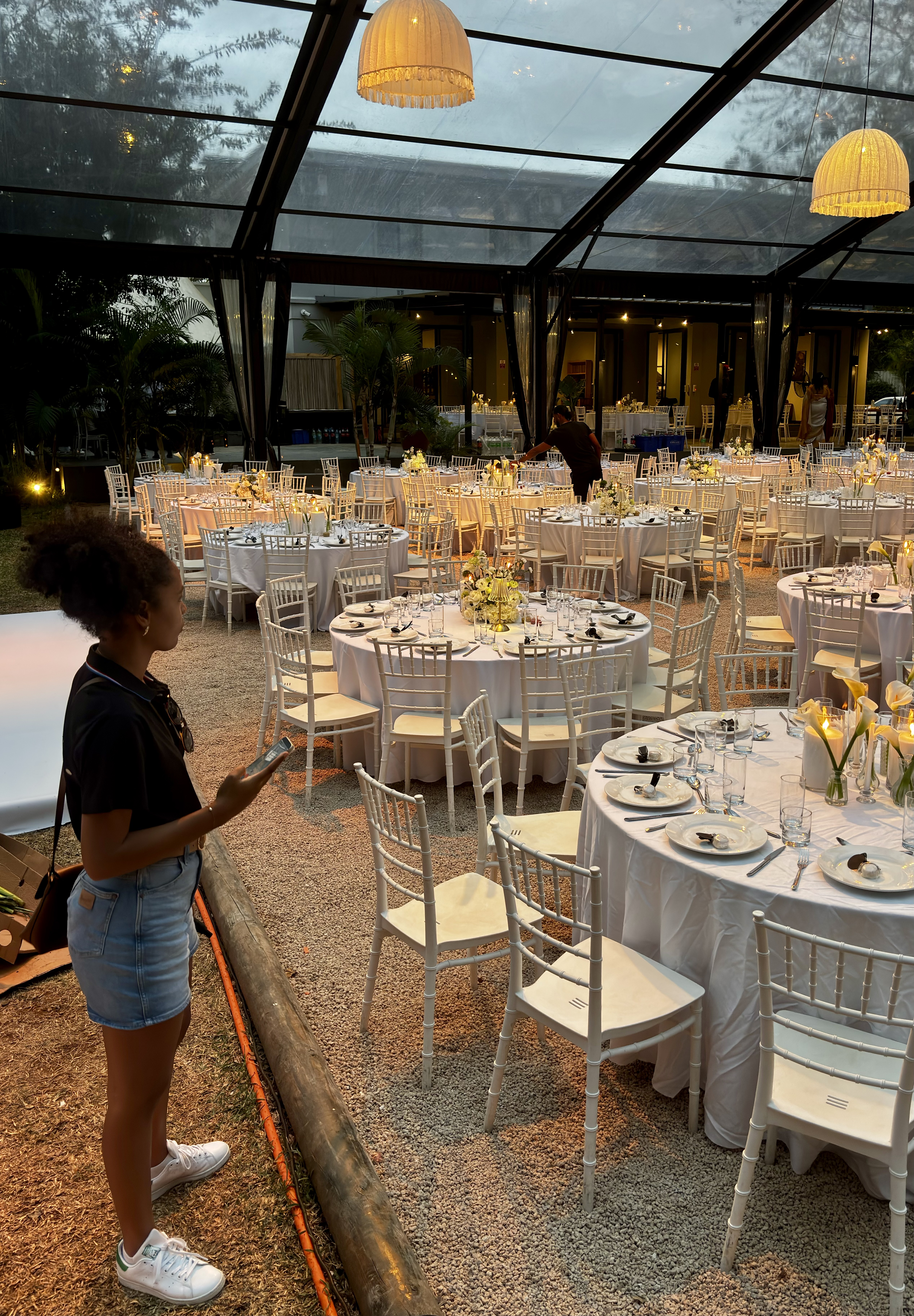 Allée de tables rondes dressées sous une structure événementielle