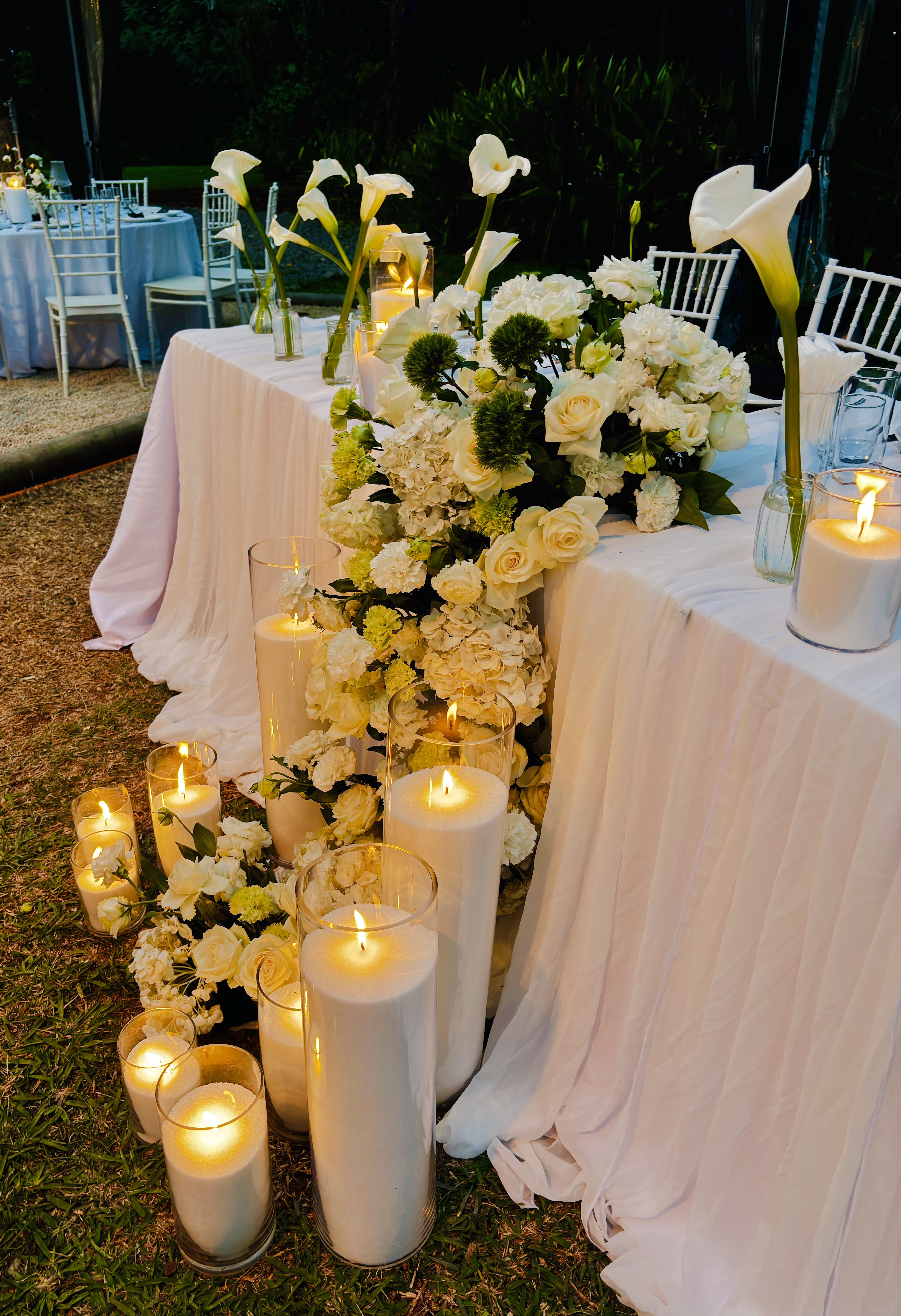 Centre de table floral avec roses blanches et photophores en verre