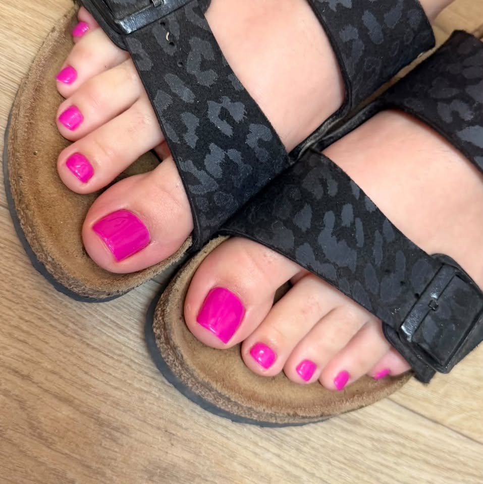 Bright pink toenails in black sandals