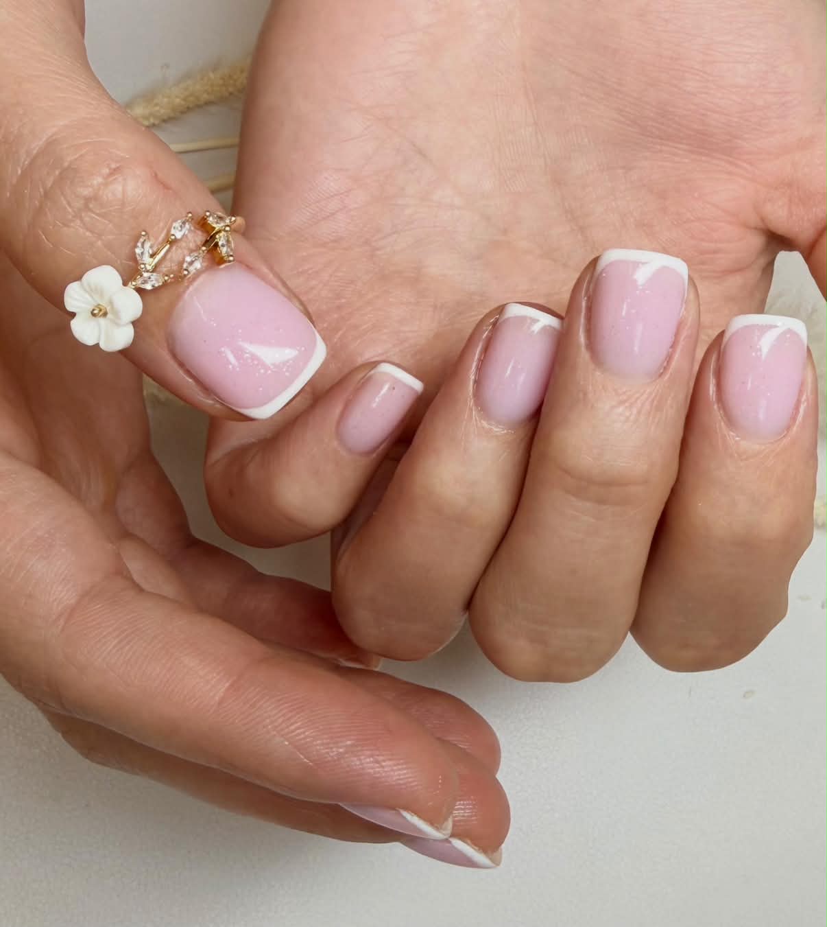 Soft shimmering pink nails with fine white French tips