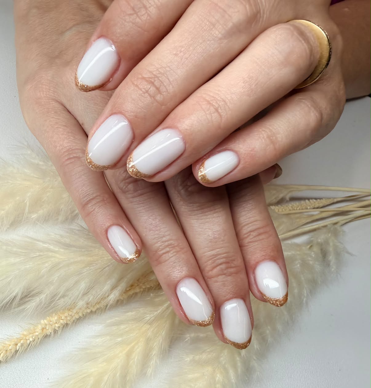 White nails with gold glitter tips