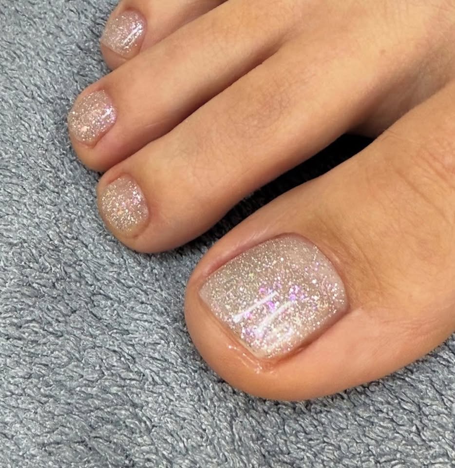 Toenails with a pale glitter polish finish