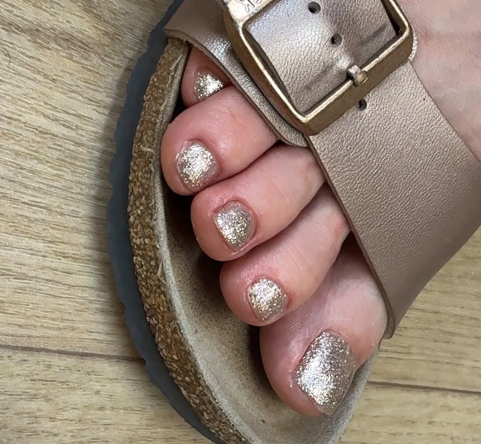 Silver glitter toenails in a metallic sandal