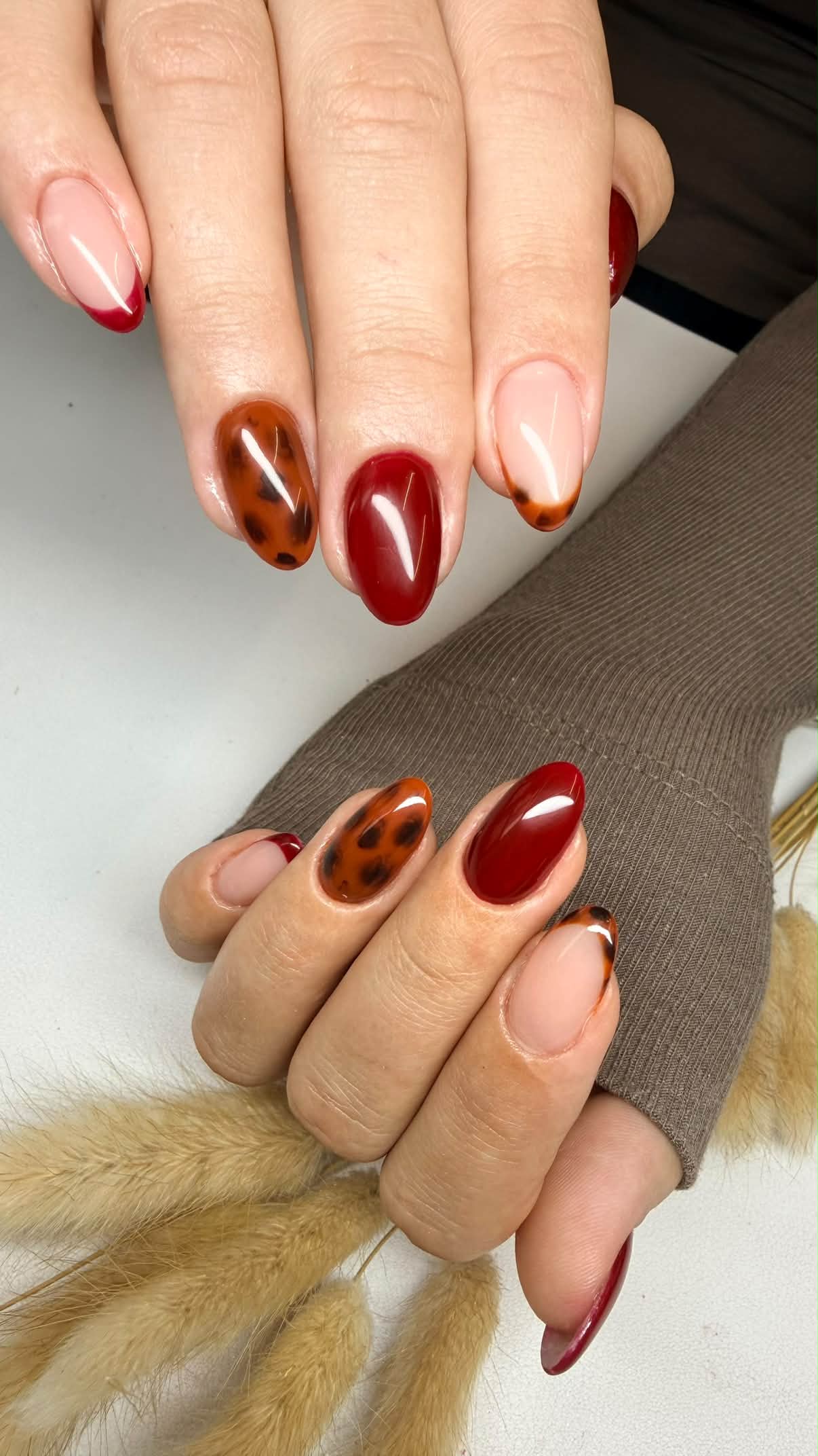 Burgundy and tortoiseshell almond nails with nude French accents