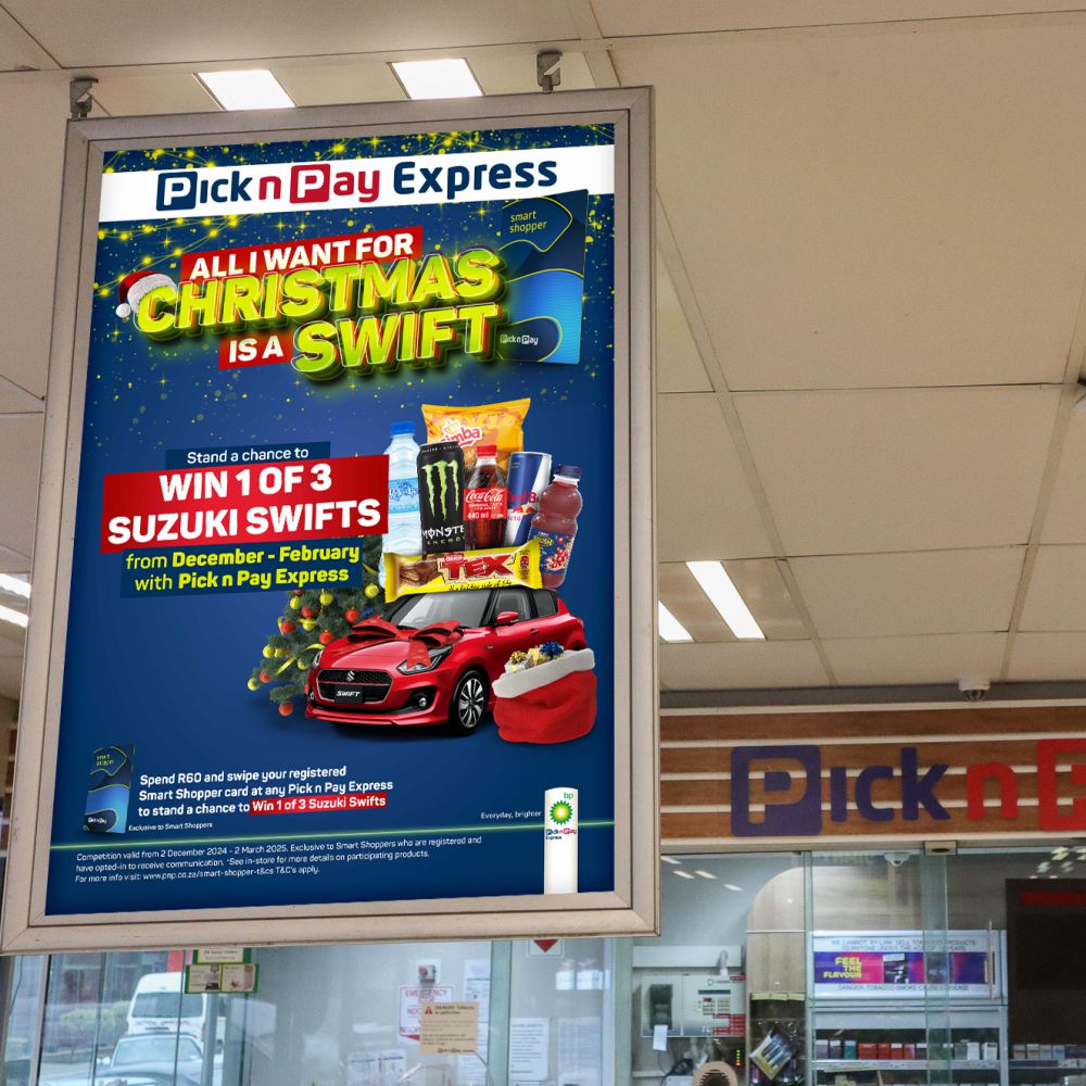 Pick n Pay Express All I Want for Christmas Is a Swift promotional hanging poster featuring a red Suzuki Swift with a bow, a Christmas stocking of gifts and the Win 1 of 3 Suzuki Swifts competition on a deep blue background with gold sparkles.