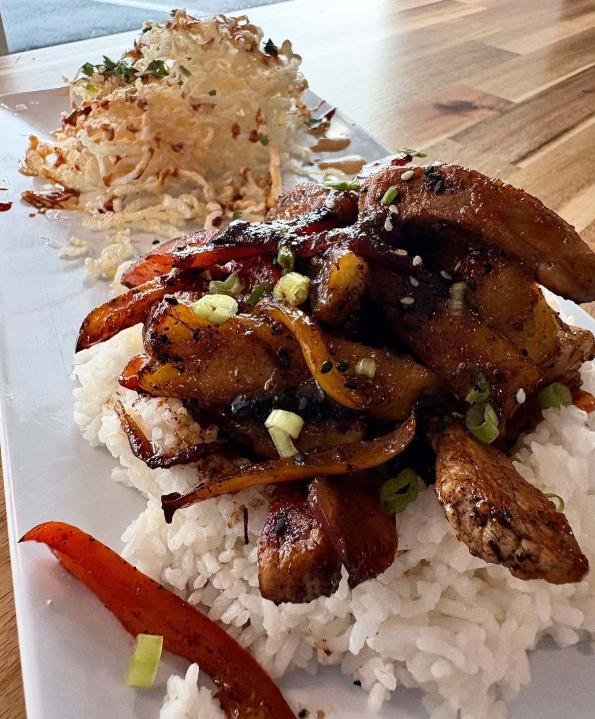 Glazed chicken over rice with crispy onions
