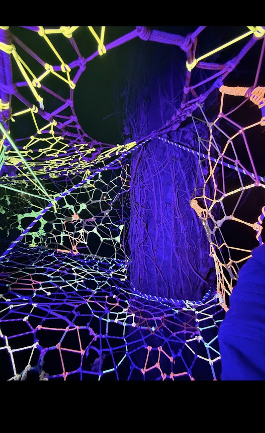 Immersive UV tunnel wrapping the trunk in neon lime, orange and purple