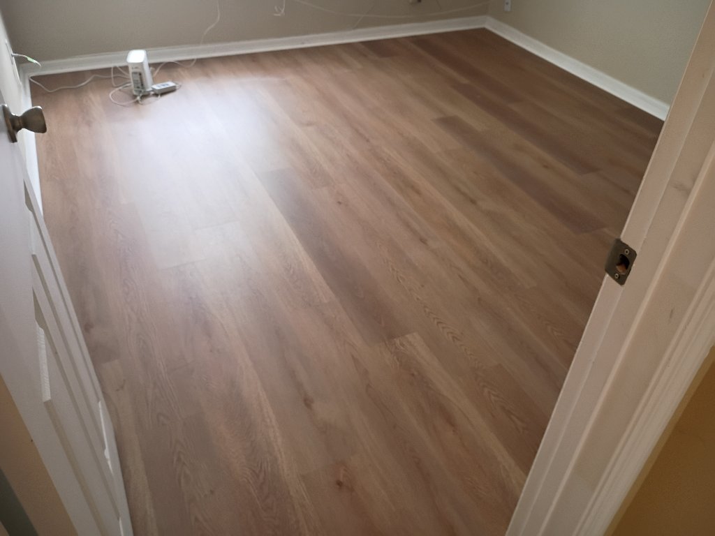 Professional flooring installation by PTAH Flooring showing Wismar Oak luxury vinyl planks from doorway perspective