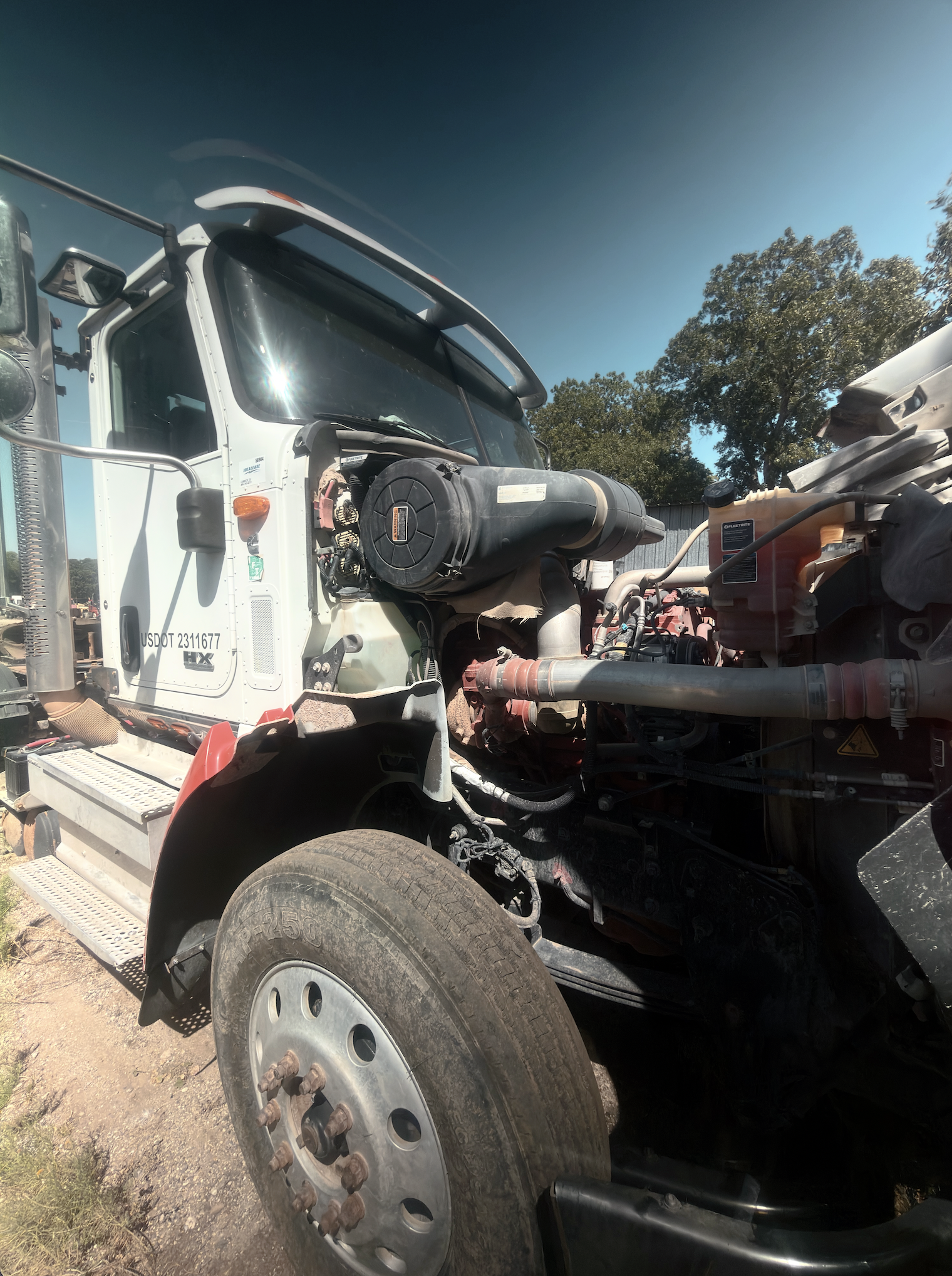 Commercial tractor with hood tilted forward exposing engine for DOT inspection and repair