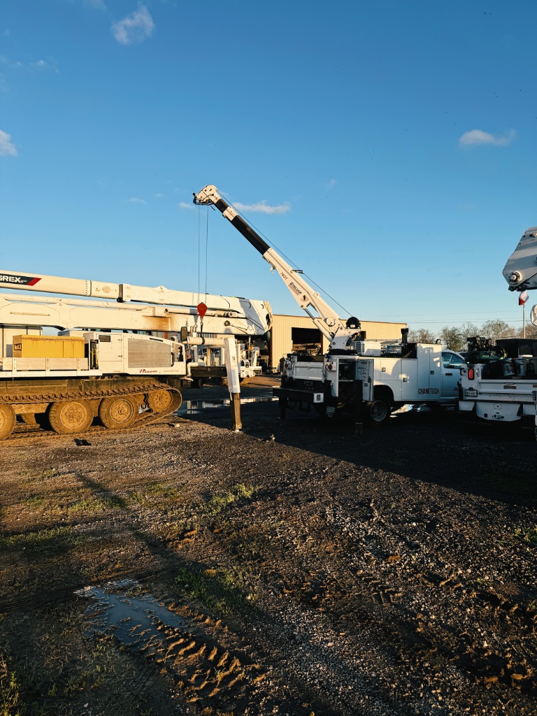 Contractor fleet oil change — CRANETEC mobile service unit and utility crane equipment at staging yard