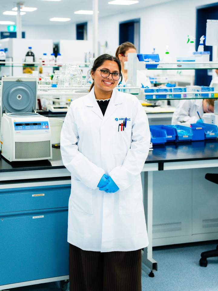 Young woman in a white lab coat working in a manufacturing laboratory