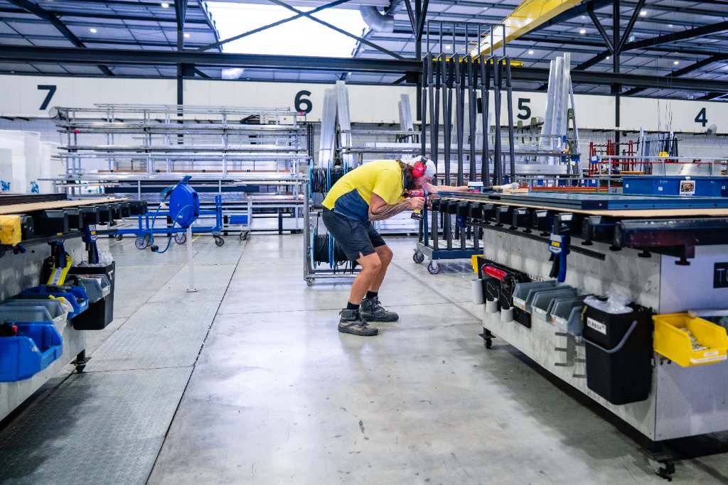 Worker drilling on factory floor