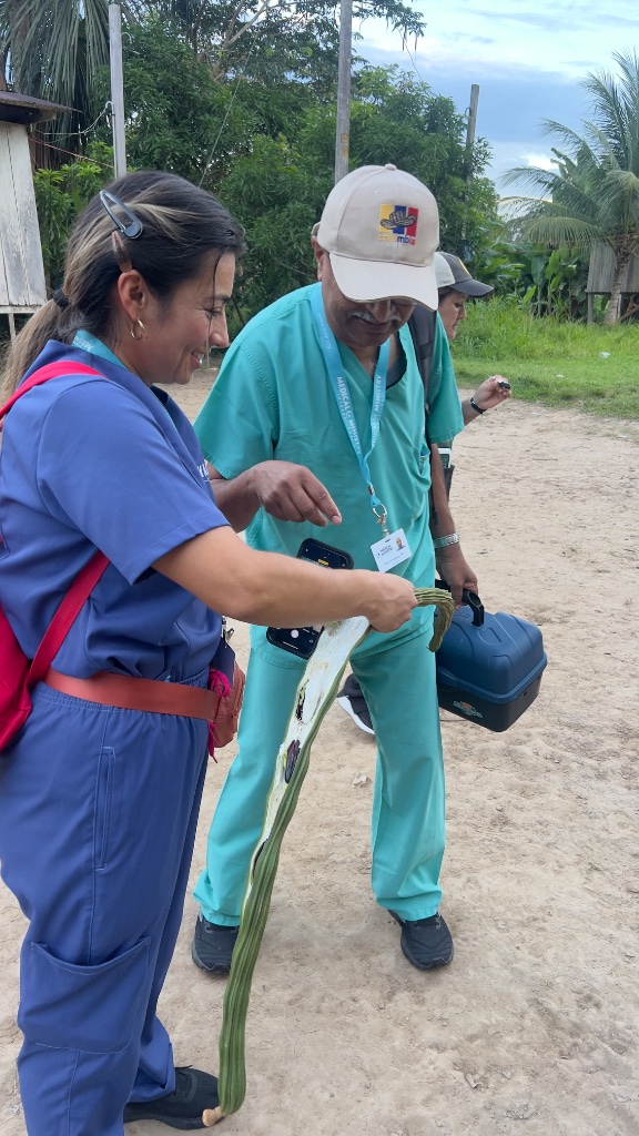 Across the Amazon — a medical worker and a local woman examining a plant together