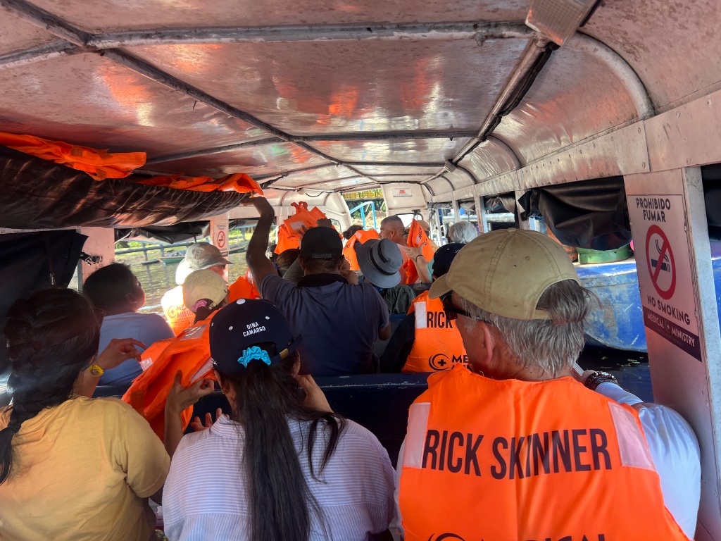 Across the Amazon — volunteers travelling the river aboard the floating medical boat in orange life vests