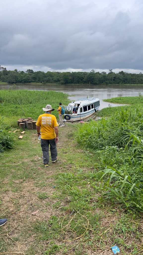 Across the Amazon — a member of the team walking toward the medical boat on the riverbank
