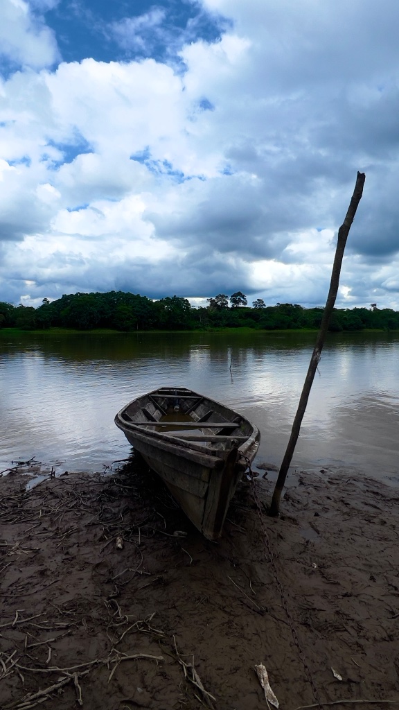 Across the Amazon — the medical team's boat moored at the riverbank under a heavy sky