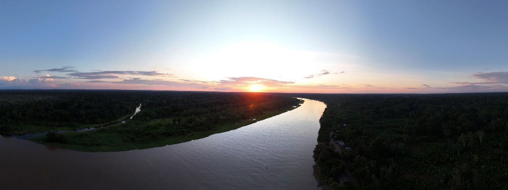 Across the Amazon — aerial view of the river winding through the rainforest at sunset