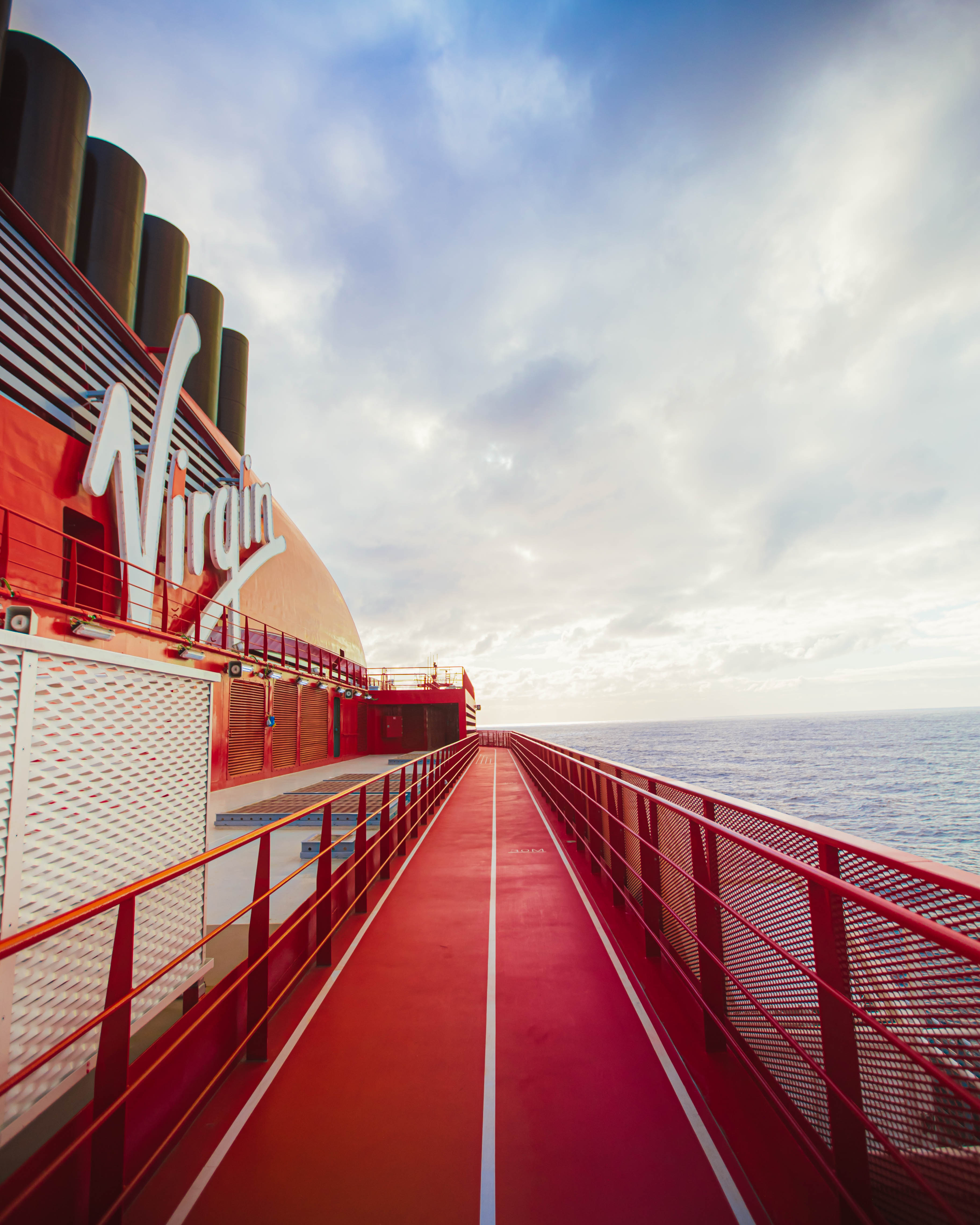 The red running track looping the deck of a Virgin Voyages ship at sea