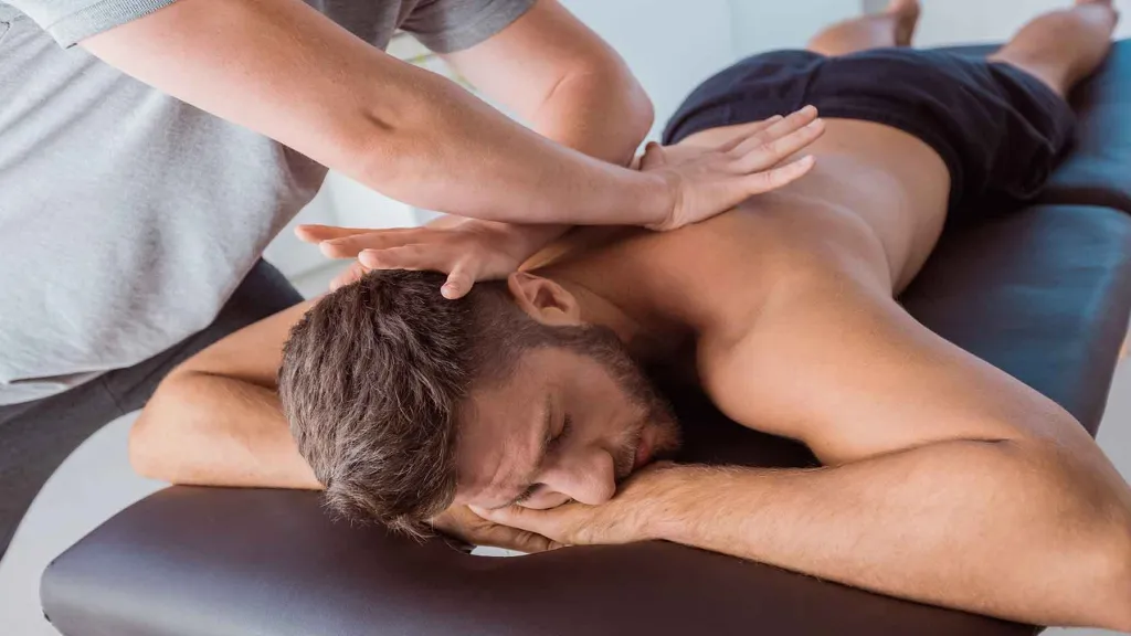 Professional M4M gay massage therapist providing deep tissue massage to male client