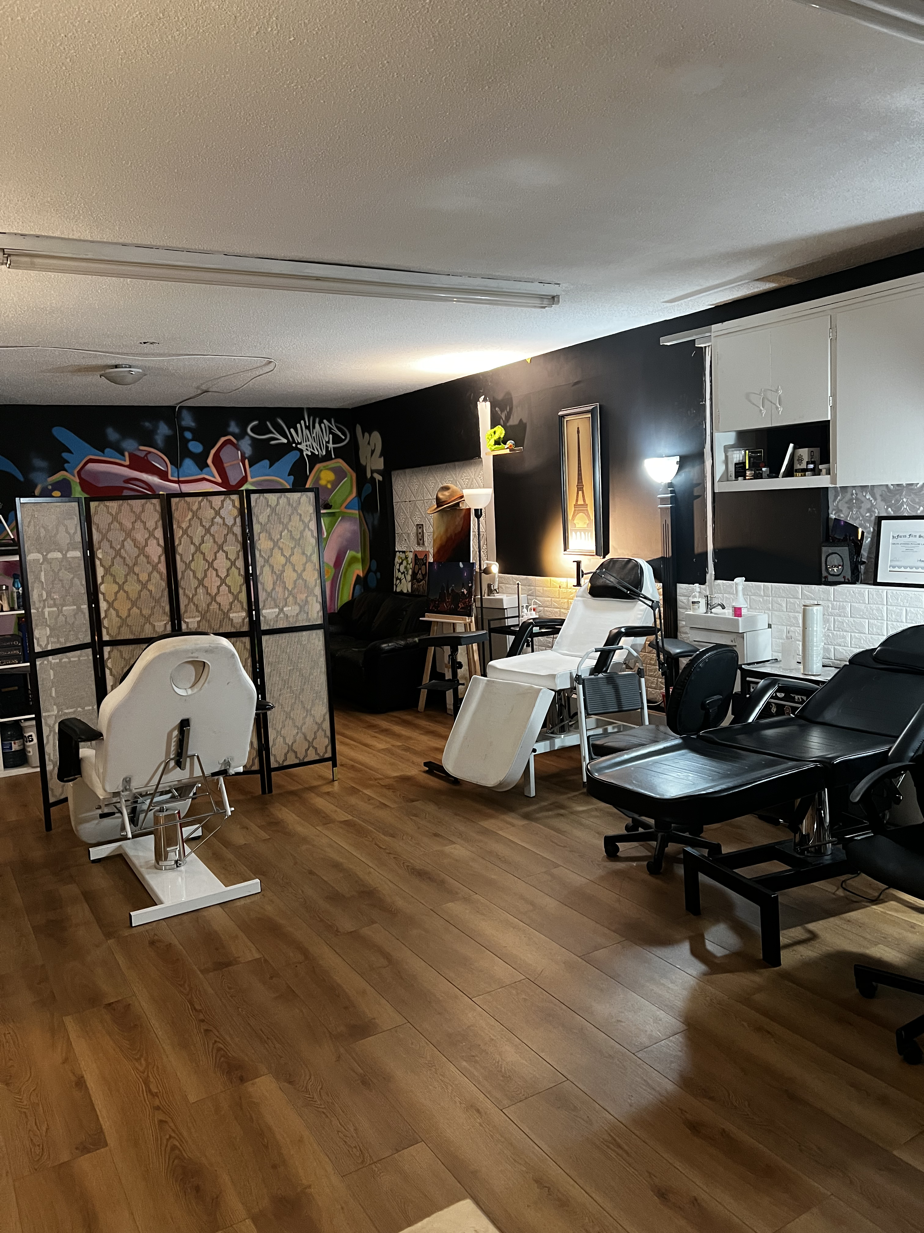 Interior of LATINK ROSE Tattoo Studio — black walls, graffiti mural and white brick at 486 E Columbia St, New Westminster BC