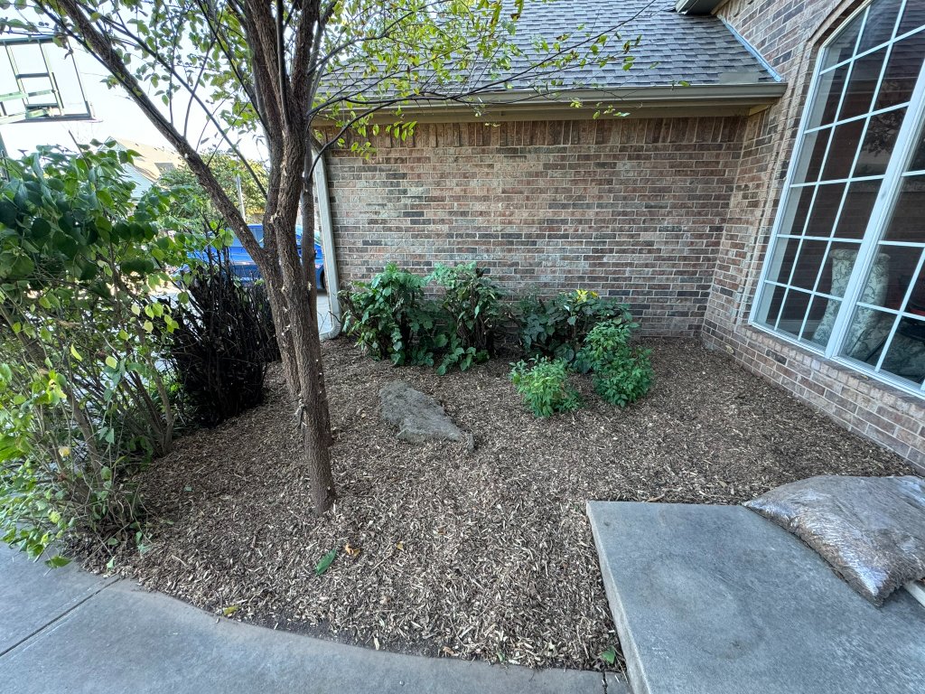 Mulched planting bed with shrubs and boulders from an ATS Stillwater residential project