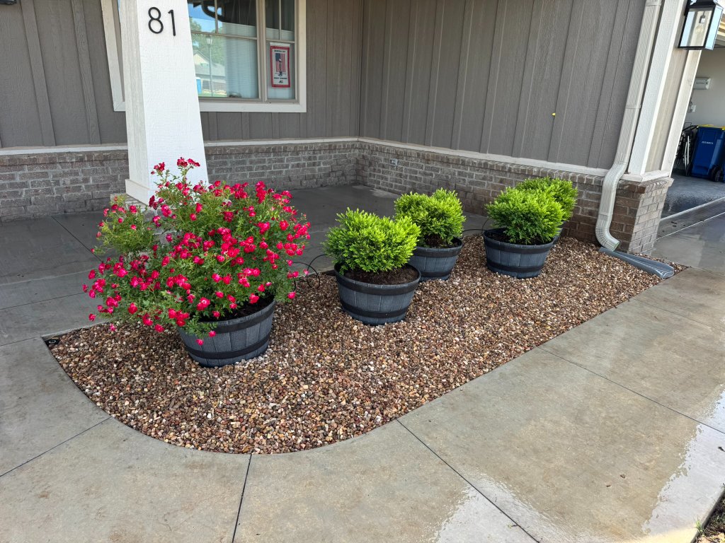 Decorative rock bed and potted plants from an ATS residential flowerbed project in Stillwater