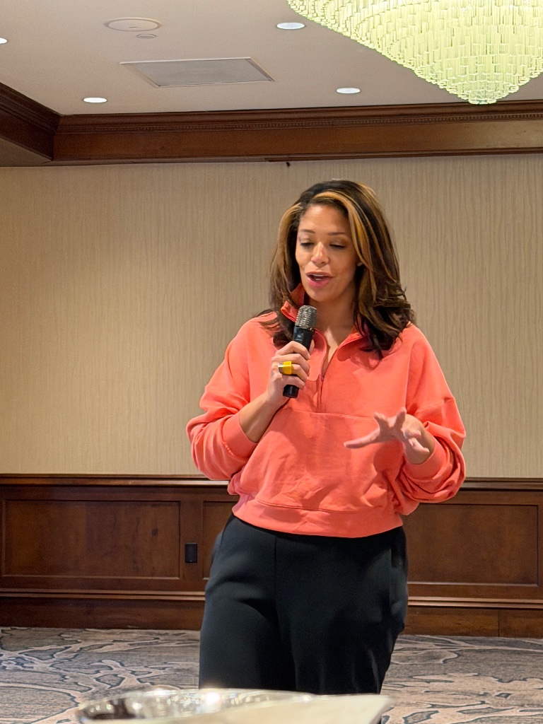 Lacey speaking at hotel ballroom event
