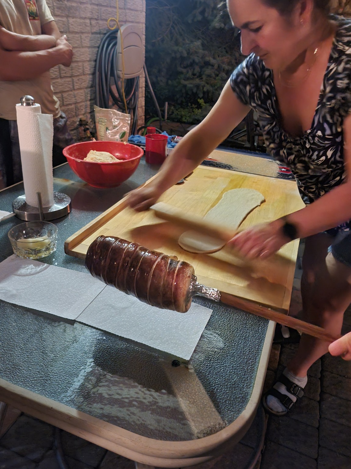Rolling chimney cake dough by hand on a wooden board