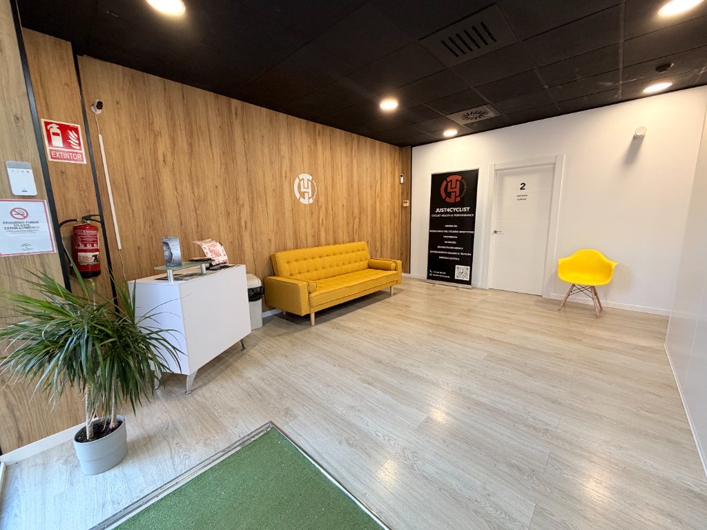 Sala de espera de JUST4CYCLIST con logo Corporativo y banner de servicios en Málaga