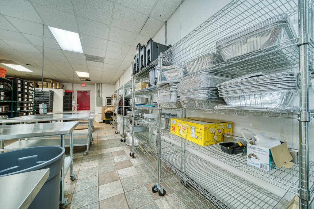 Kitchen storage area with wire shelving and work tables