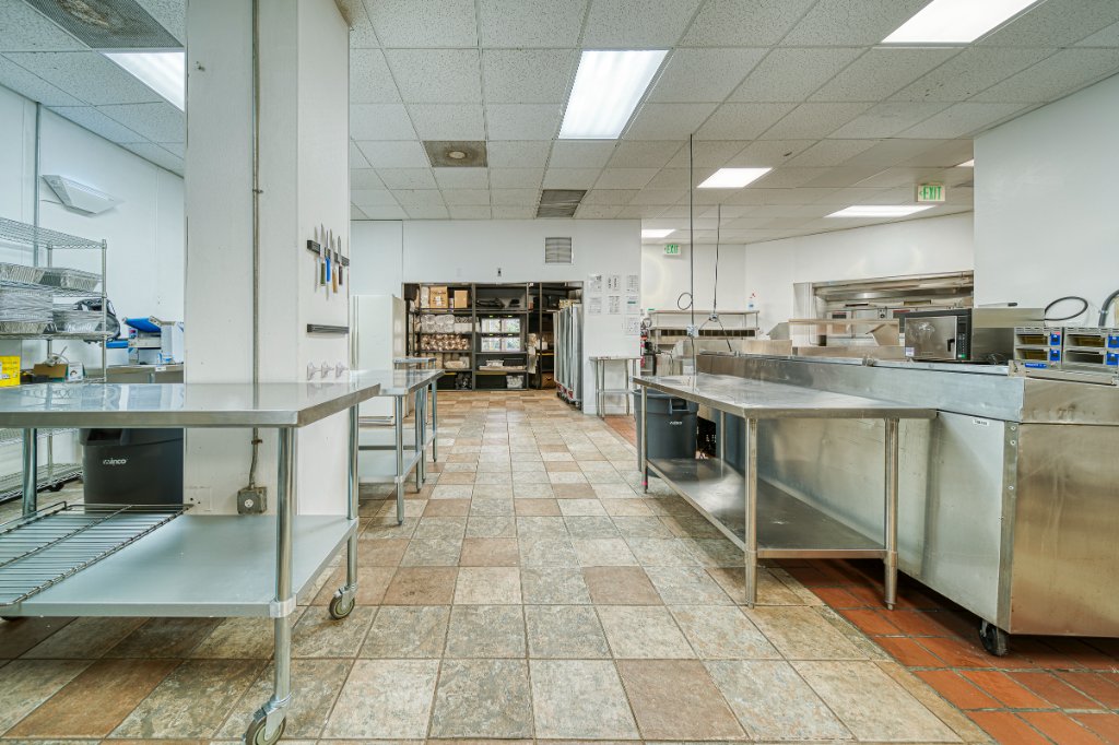 Central aisle of commercial kitchen with stainless steel workstations