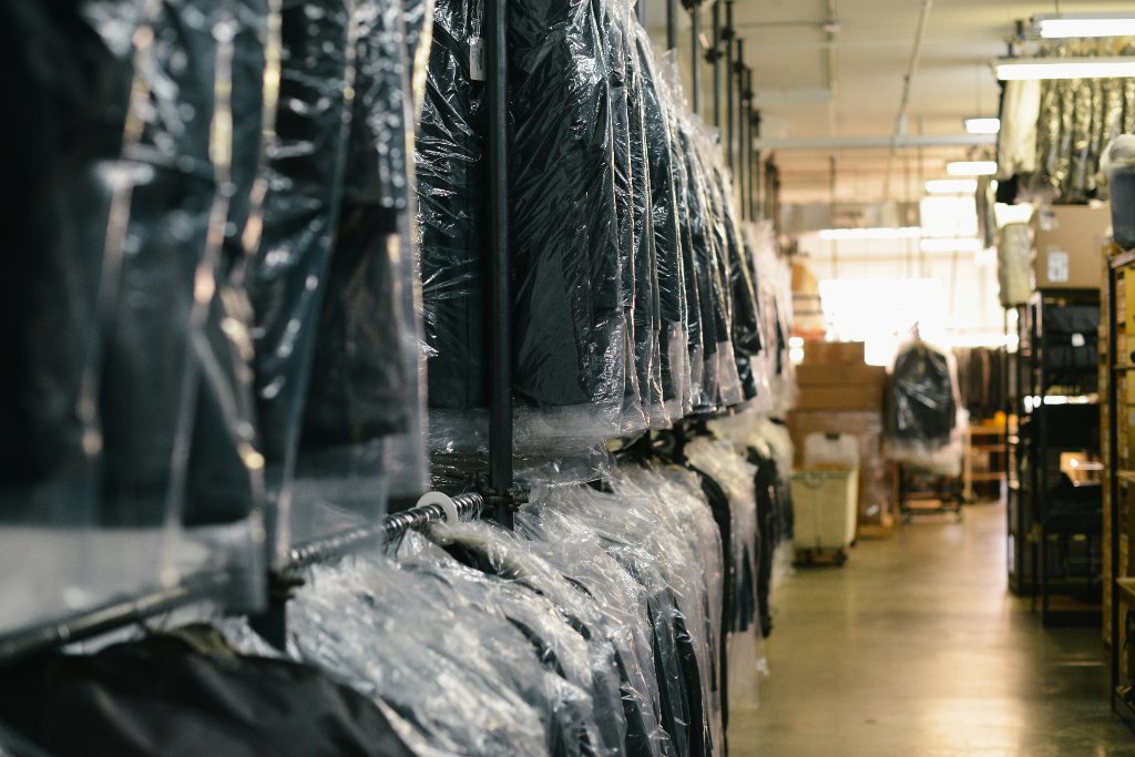 Garments hanging in protective bags inside the Magic Touch Cleaners facility