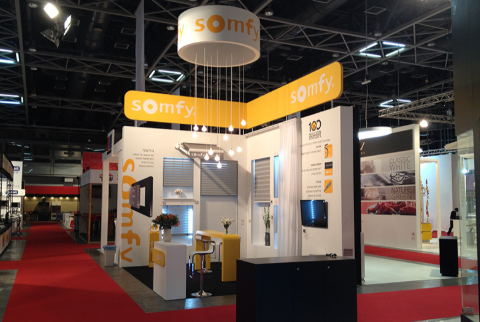 Somfy smart-home exhibition booth — orange & white branded environment