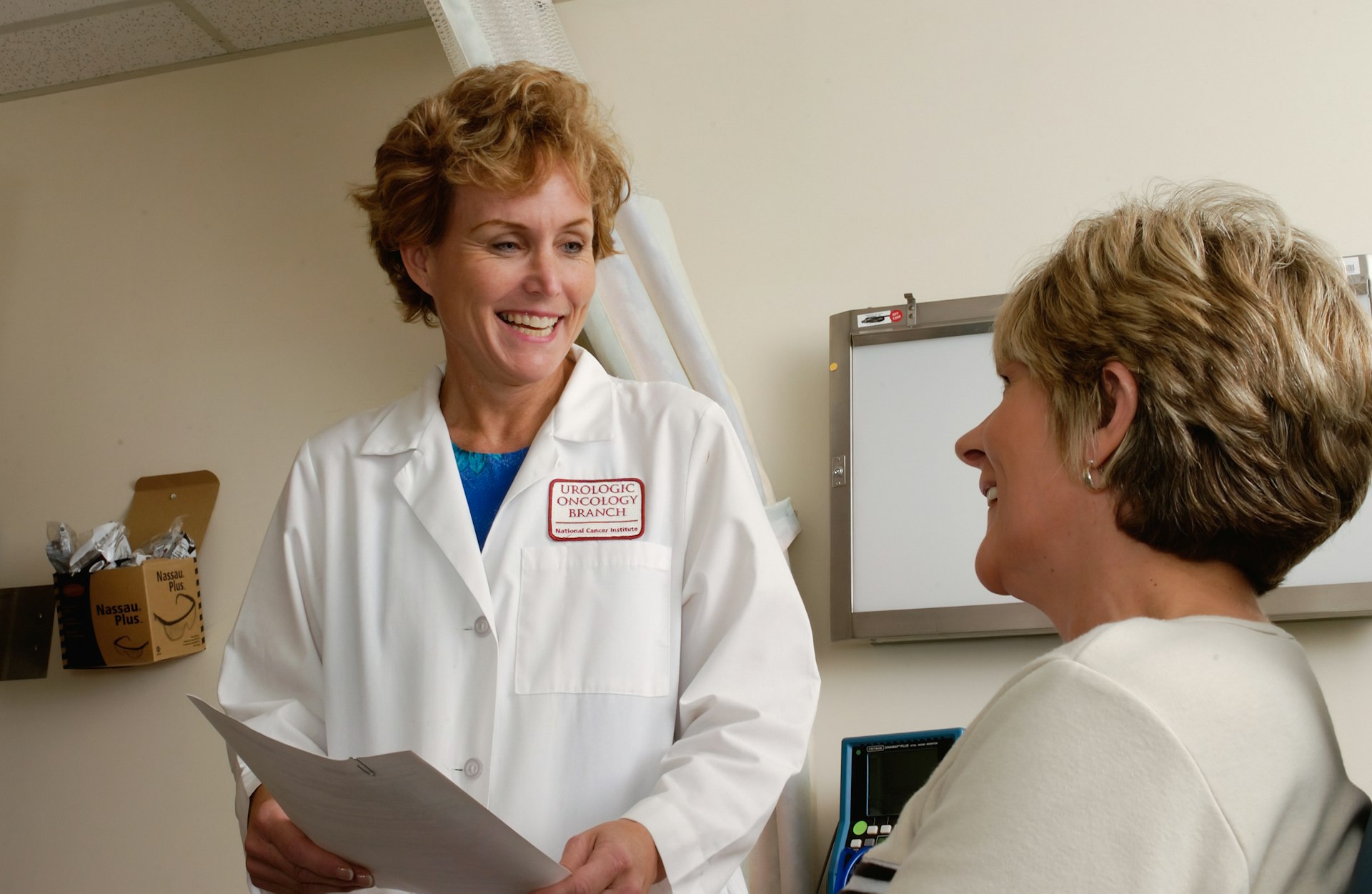 Elysian Health doctor warmly consulting a female patient in a bright, reassuring clinic office.