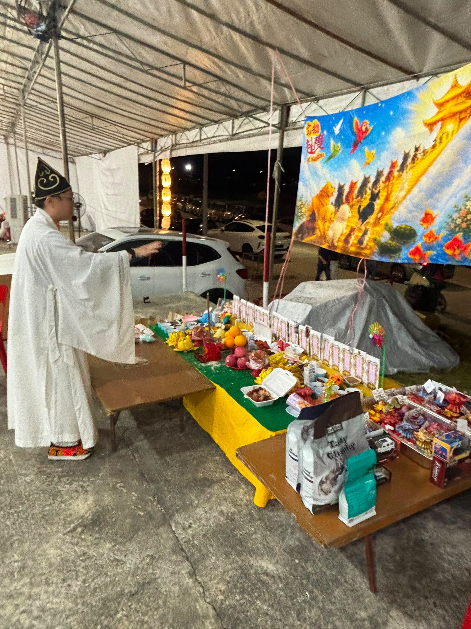 As night falls, a Taoist priest performs the final send-off, dedicating prayers to the departed.