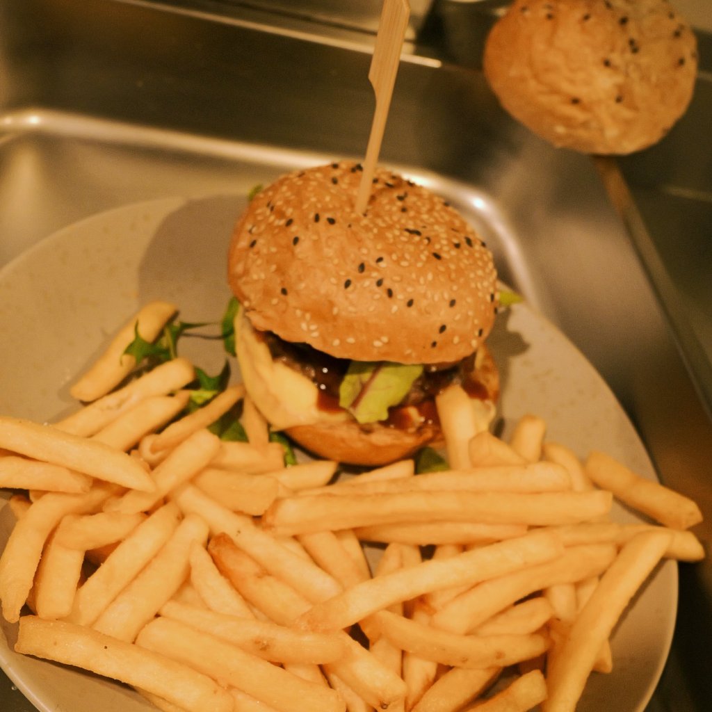 Beef burger with chips freshly plated in the kitchen at City Chicks farm cafe, Samford Valley near Mt Glorious