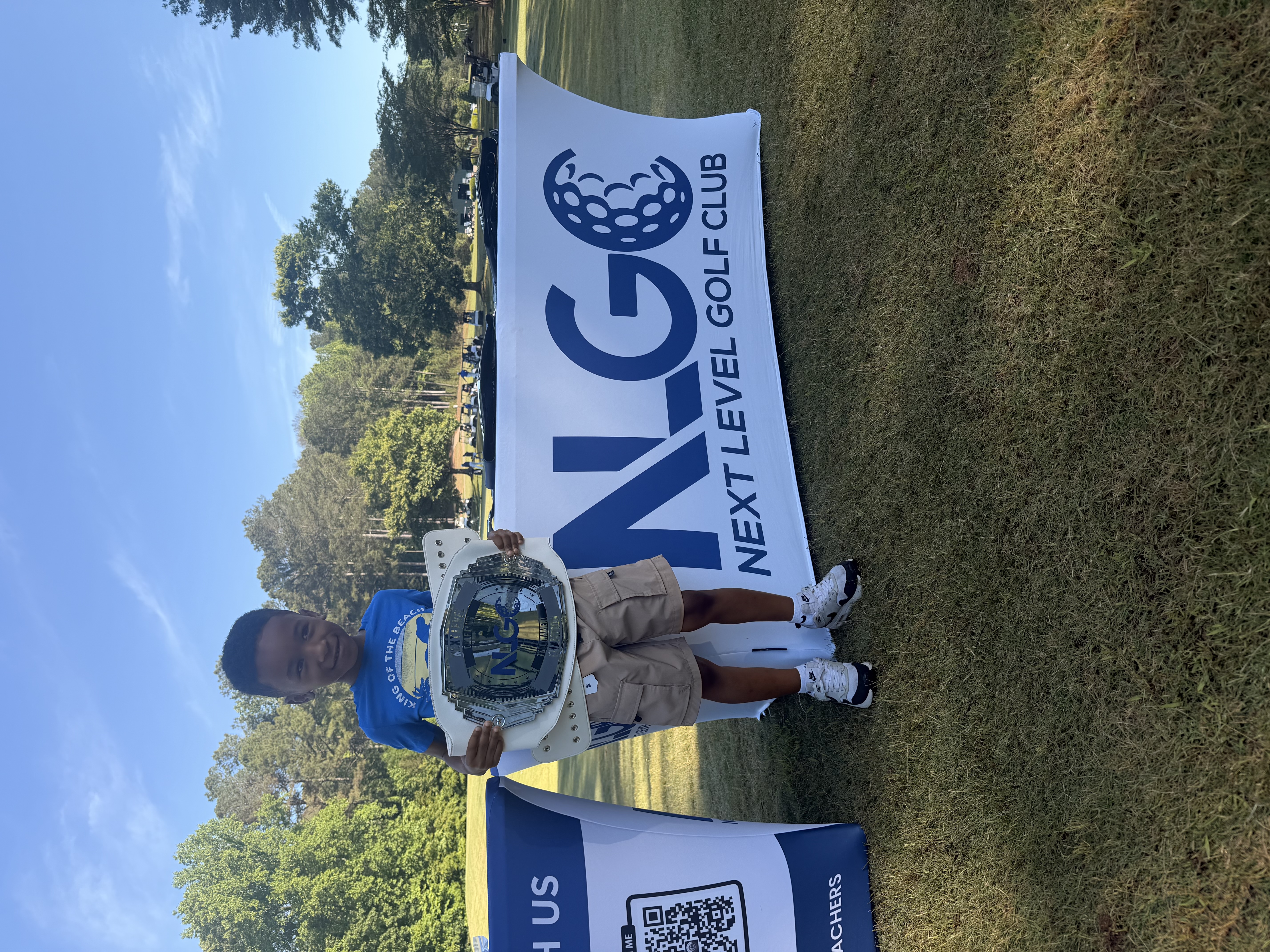 Young golfer holding a championship belt