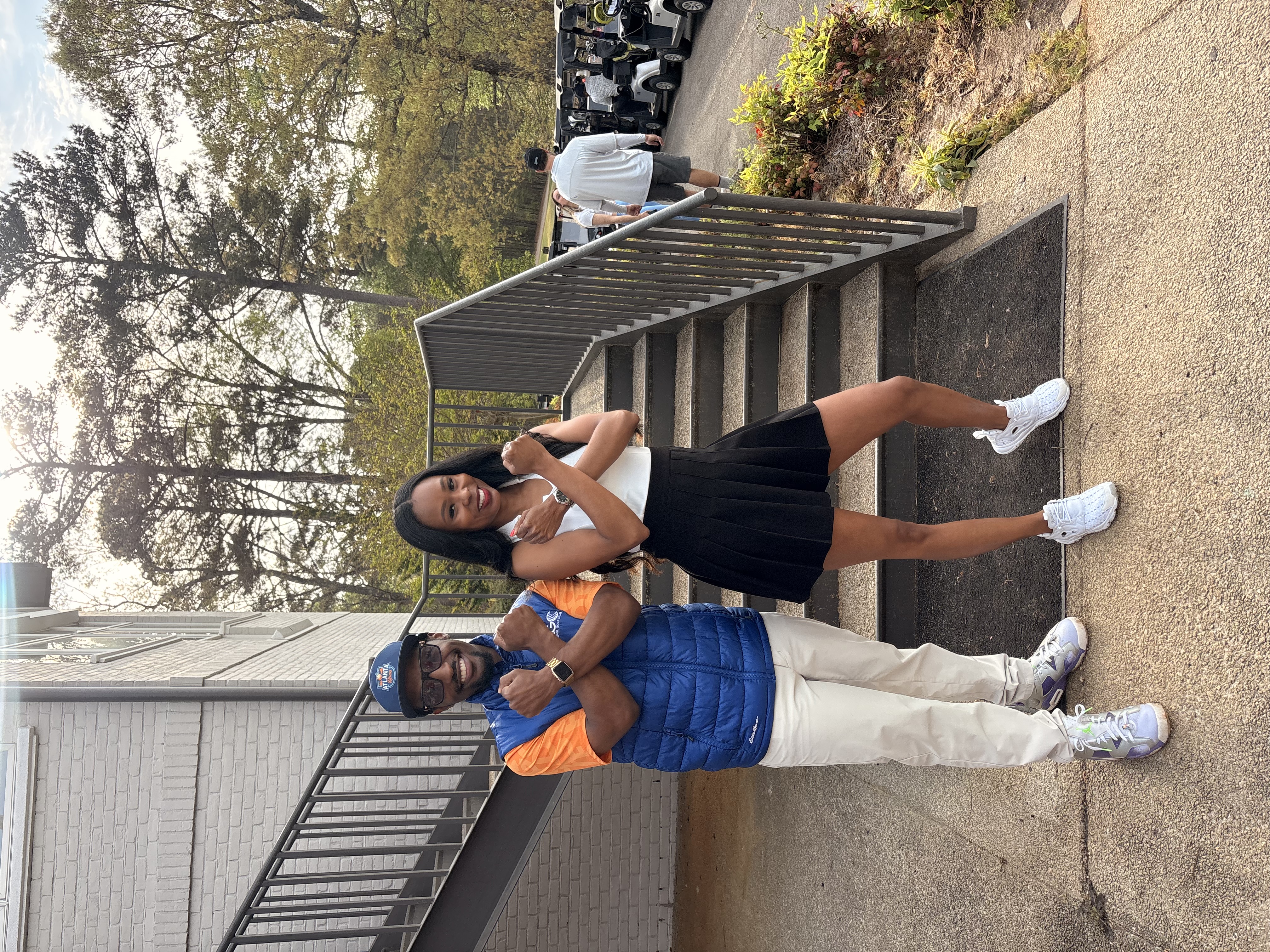 Two community members posing on an outdoor staircase