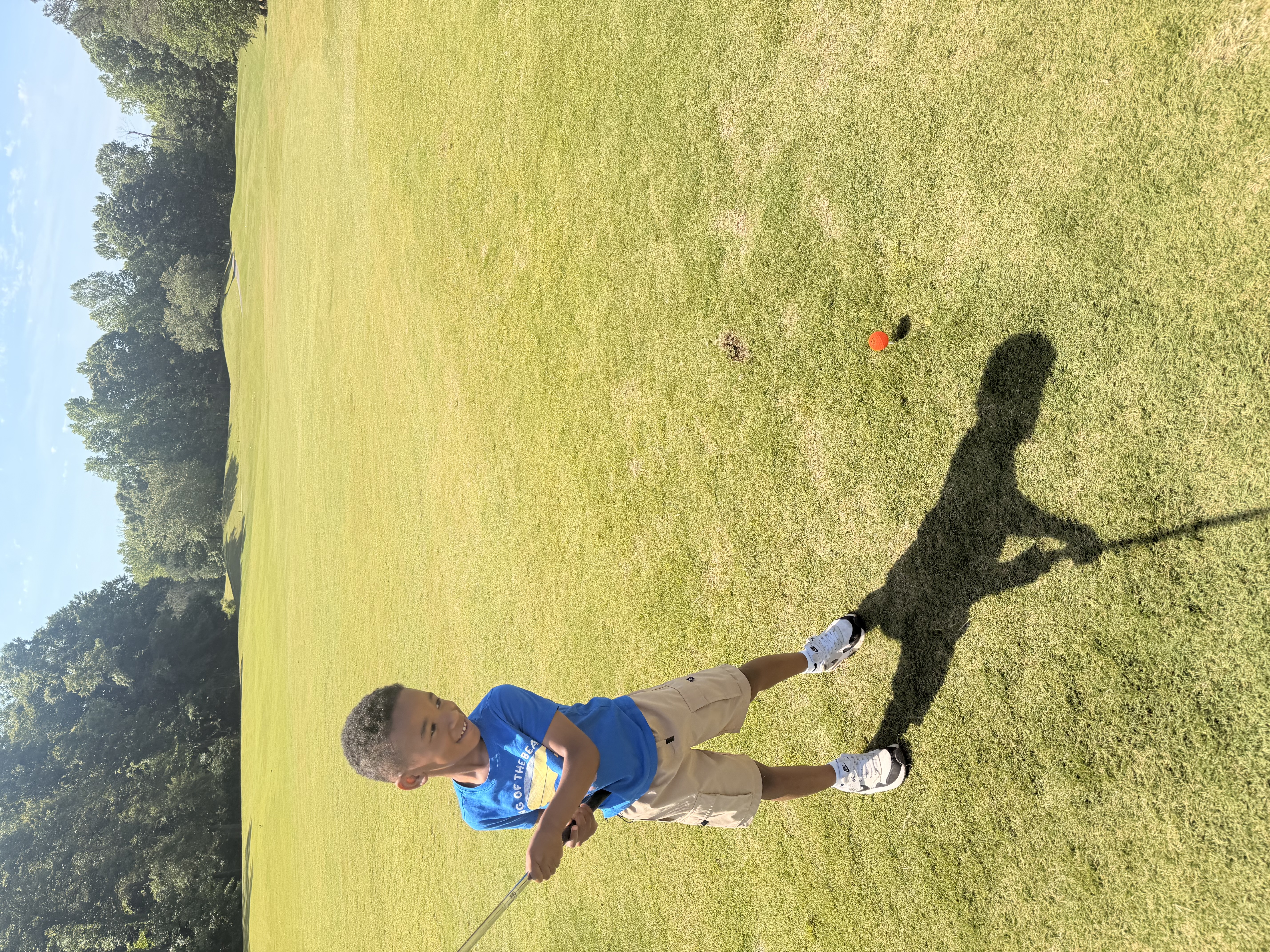Young golfer posing on the course with a club