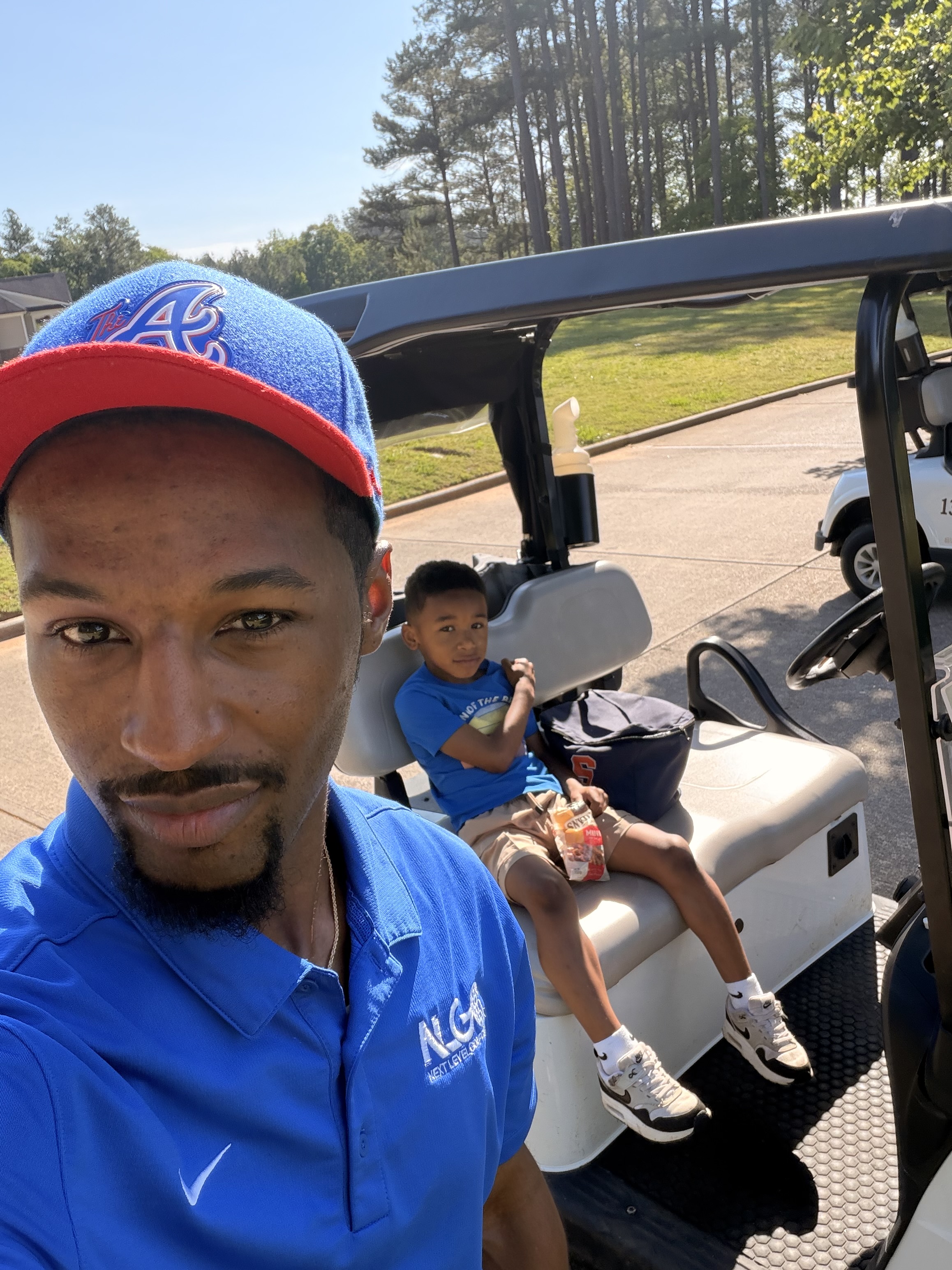 Parent and child riding in a golf cart together