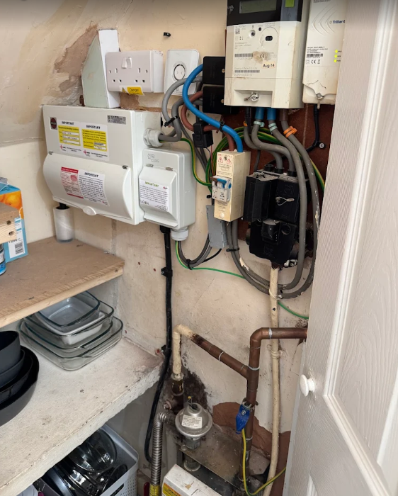 Utility cupboard electrical installation with meters and wiring