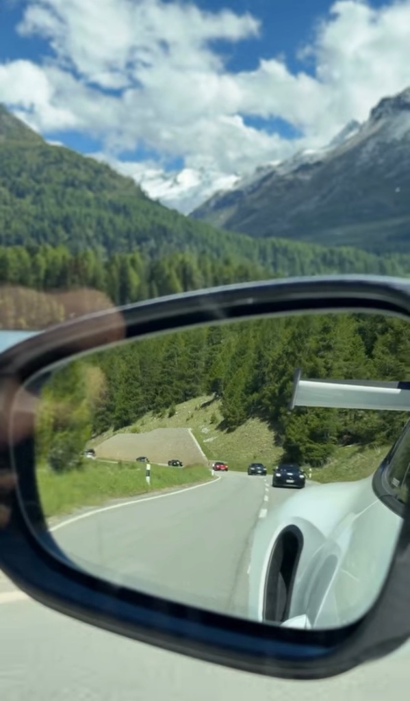 Sportwagen im Rückspiegel Alpen