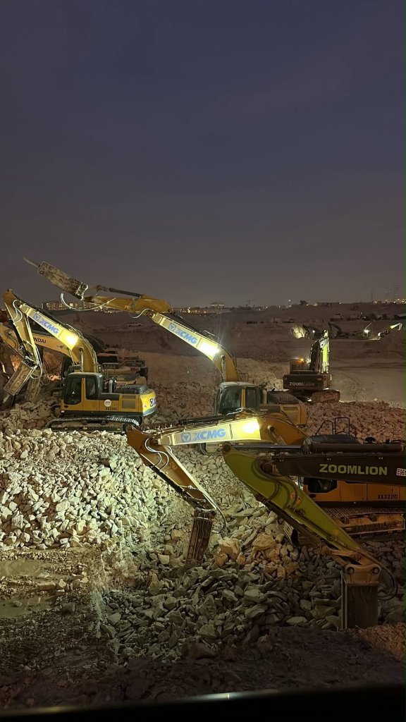 Excavation site at night with hydraulic rock breakers